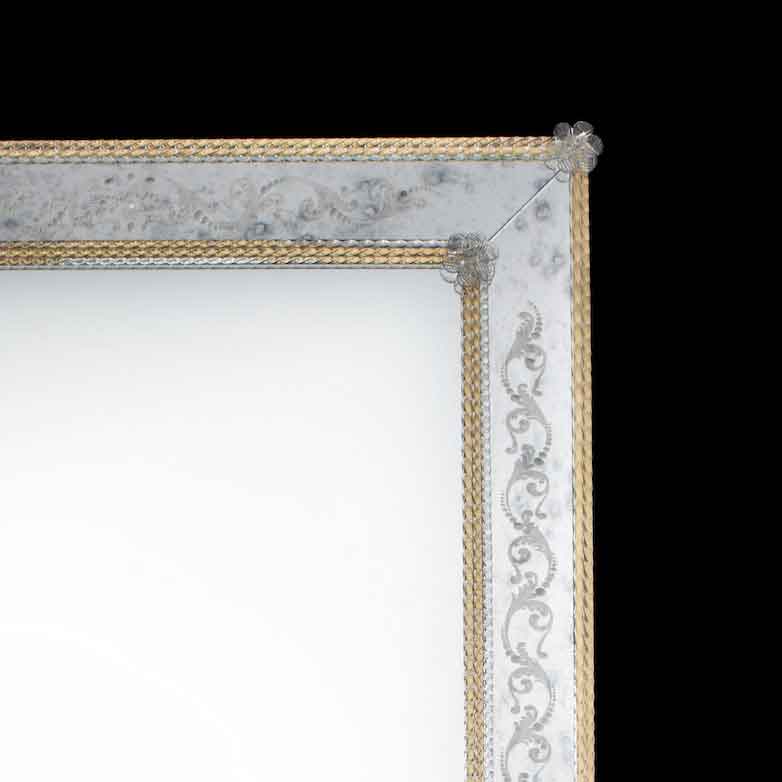 angolatura di specchio veneziano con lastra centrale specchiata e fasce laterali anticate e incise a mano, fiori e canne in vetro di Murano di colore cristallo su fondo oro
