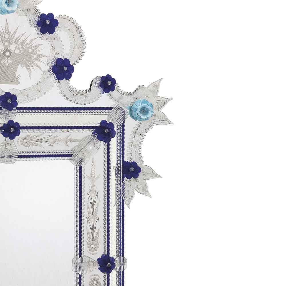 angolo di specchio classico veneziano con fasce incise a mano e fiori doppi in pasta, ricci, canne, foglie, fiori e in vetro di murano di colore cristallo e blu su fondo argento.