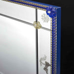 Load image into Gallery viewer, angolo di specchio veneziano rettangolare con angioletti incisi a mano sulle fasce laterali, canne e fiori in vetro di murano di colore blu e fumè su fondo argento.
