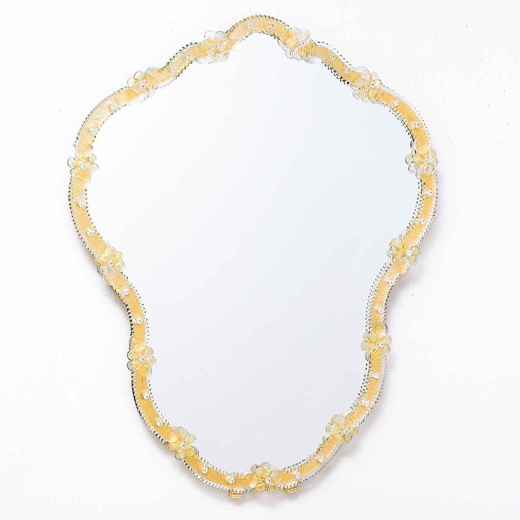 specchio veneziano da parete con ricci e fiori in vetro di murano di colore cristallo su fondo oro.