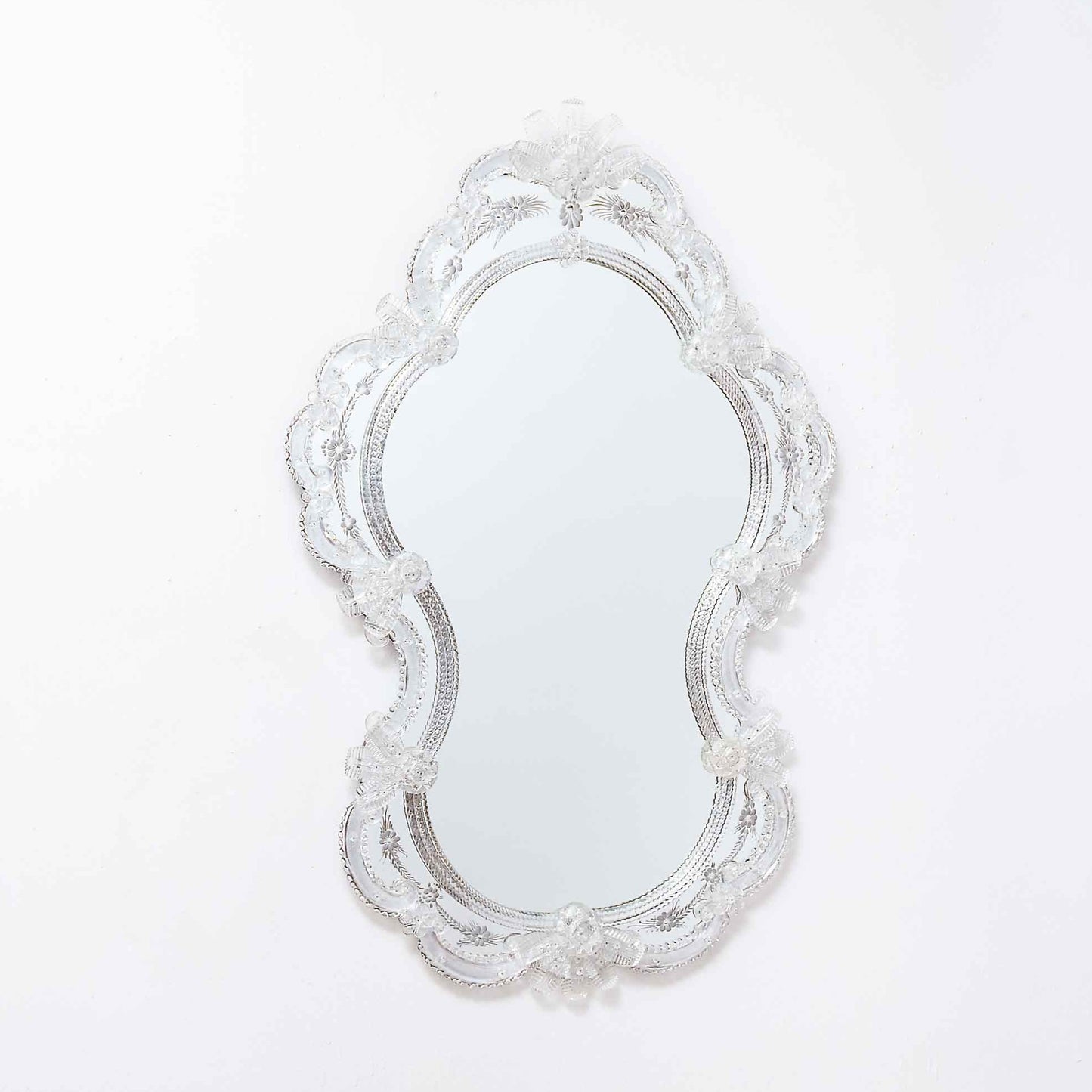 specchio veneziano stile classico con fasce incise a mano, fiori, foglie e ricci in vetro di murano, di colore  cristallo su fondo argento.